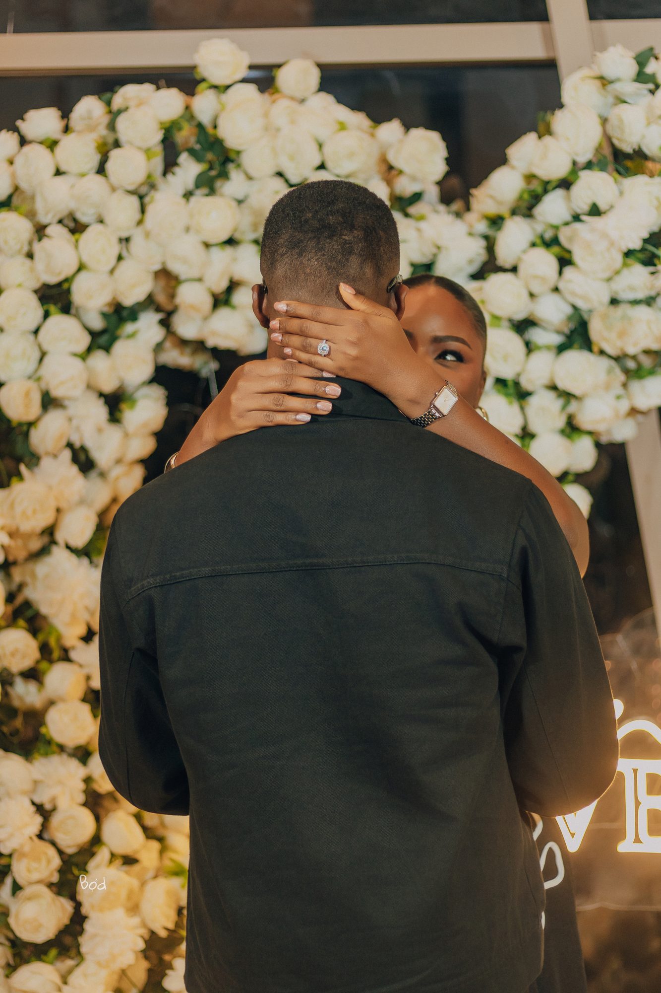 Priscilla and Kelvin from behind, hands around shoulders